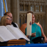 Photo of the Police Roll of Honour and candles being lit by family members in remembrance